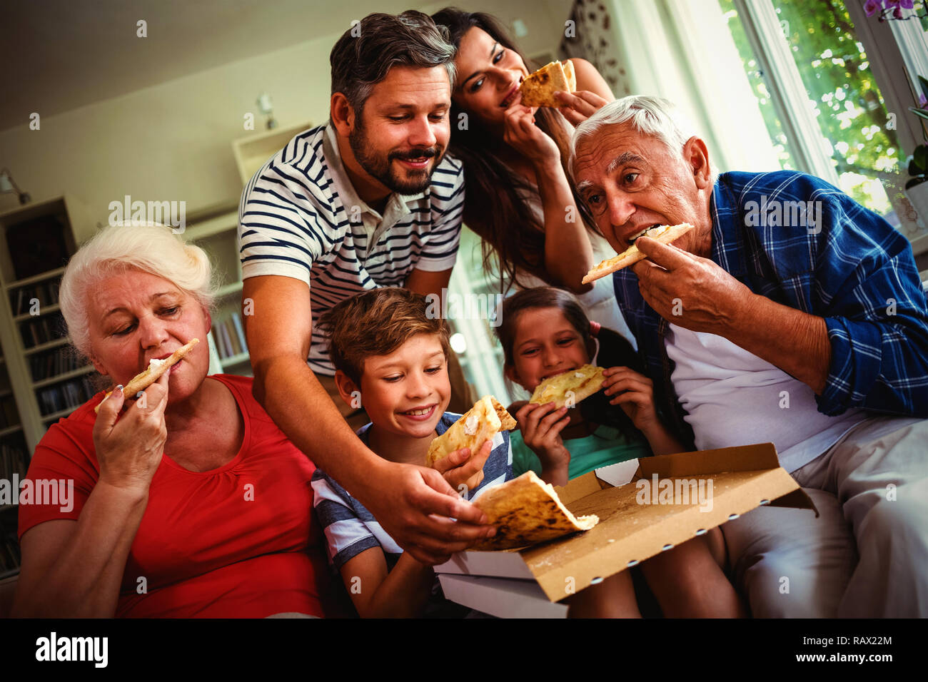 Multi-generazione famiglia mangiare la pizza insieme Foto Stock