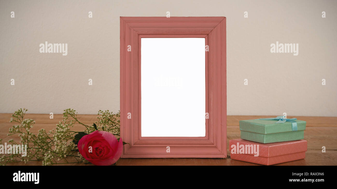 Photo Frame, rose fiore e confezioni regalo su un tavolo Foto Stock