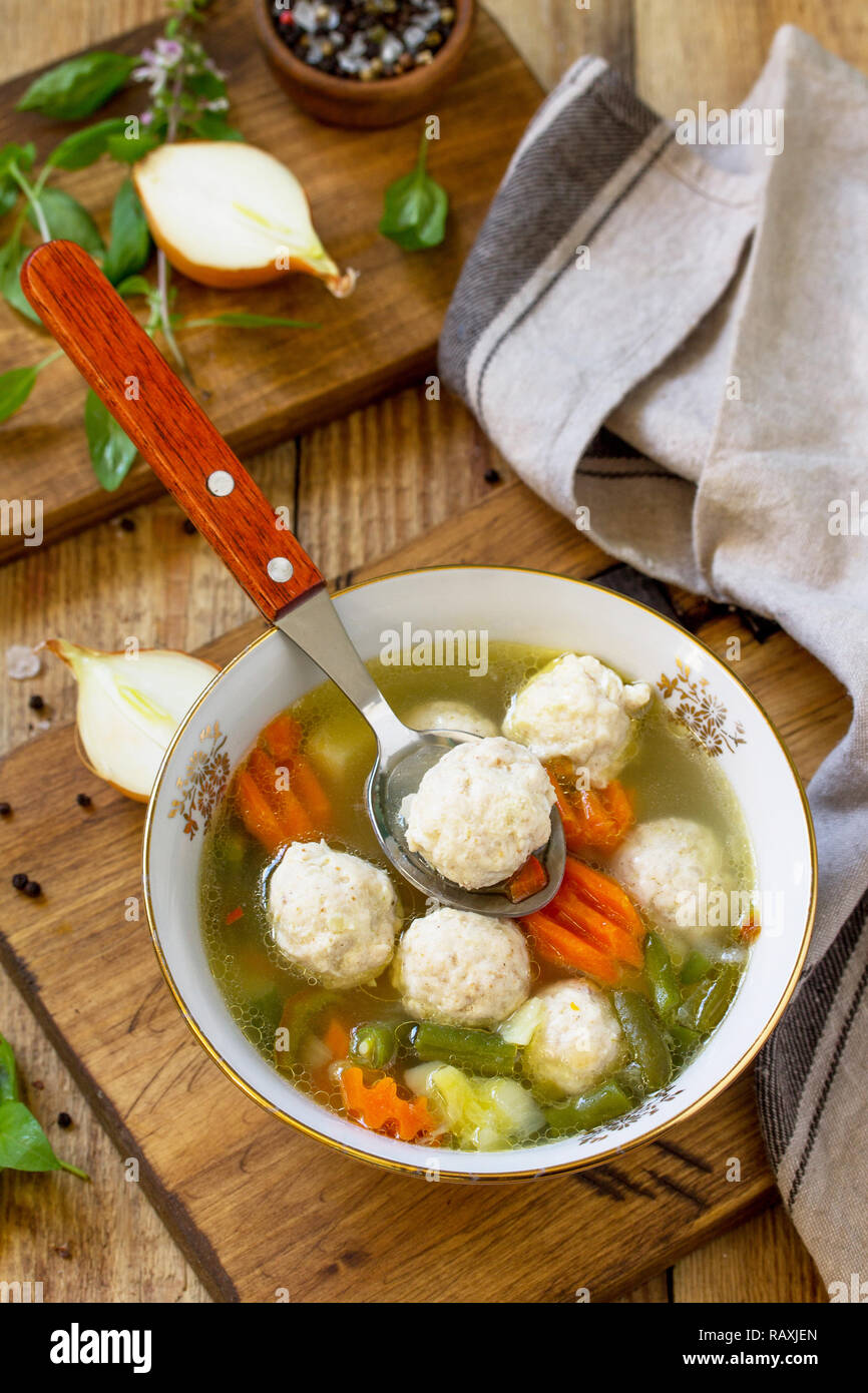Il concetto menù dietetici. Una sana zuppa di verdure e polpette di pollo in una ciotola sul tavolo in legno in stile rustico. Foto Stock