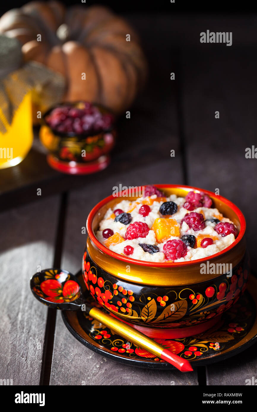 Vegano russo porridge di miglio con la zucca, frutti di bosco e uva passa nel piatto hohloma su Shrovetide vacanze Foto Stock