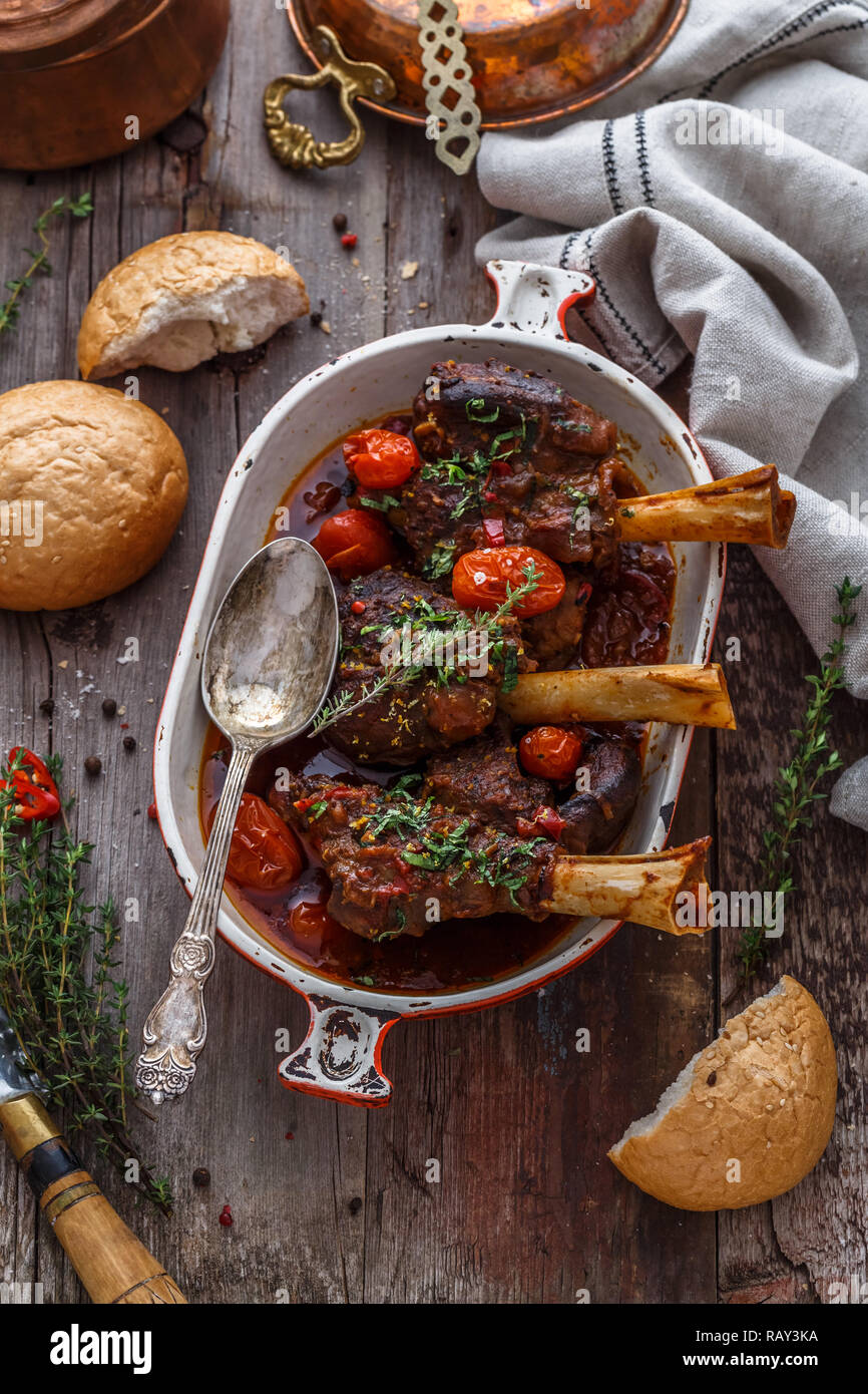 I gambi di agnello in una ricca salsa di pomodoro con pane e erbe aromatiche, vista dall'alto. Foto Stock