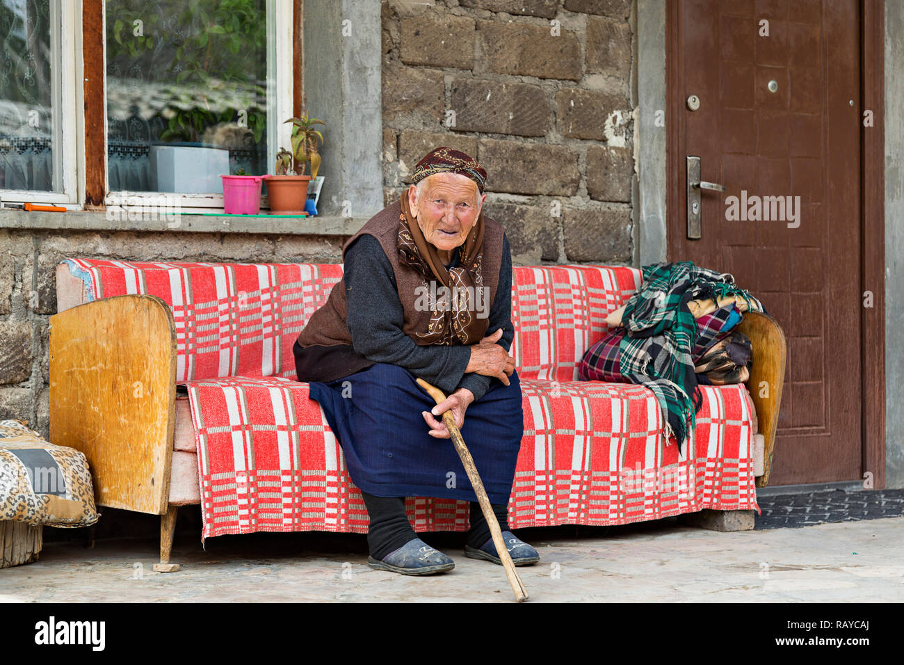 Donna armena anziana in abiti locali seduta e guardandomi, in Armenia. Foto Stock