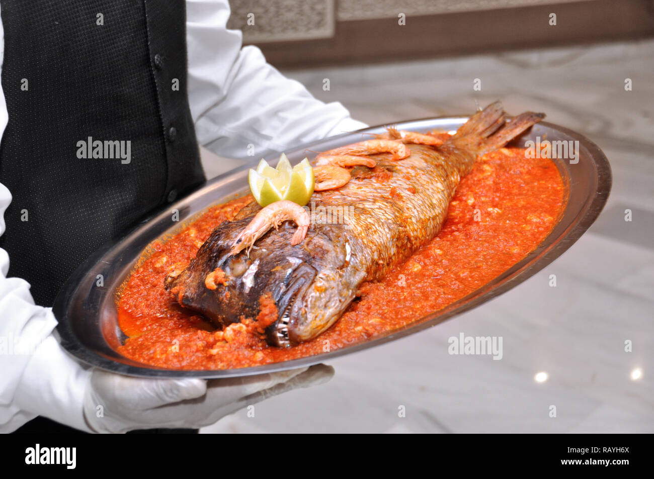 Di stile marocchino pesce è servita nel matrimonio. Il pesce con la salsa di pomodoro Foto Stock