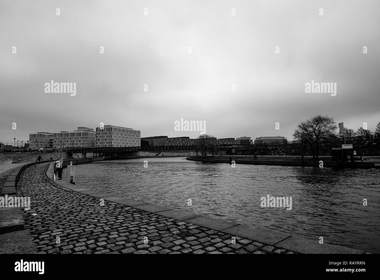 Il fiume Sprea in un giorno nuvoloso nei pressi di Berlino la principale stazione ferroviaria con interessanti edifici aziendali in background (bianco e nero) Foto Stock
