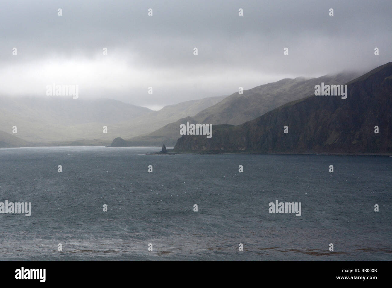 Nuvole pesanti e la pioggia sopra il mare di Bering costa di Unalaska isola, in isole Aleutian catena, Alaska, Stati Uniti Foto Stock