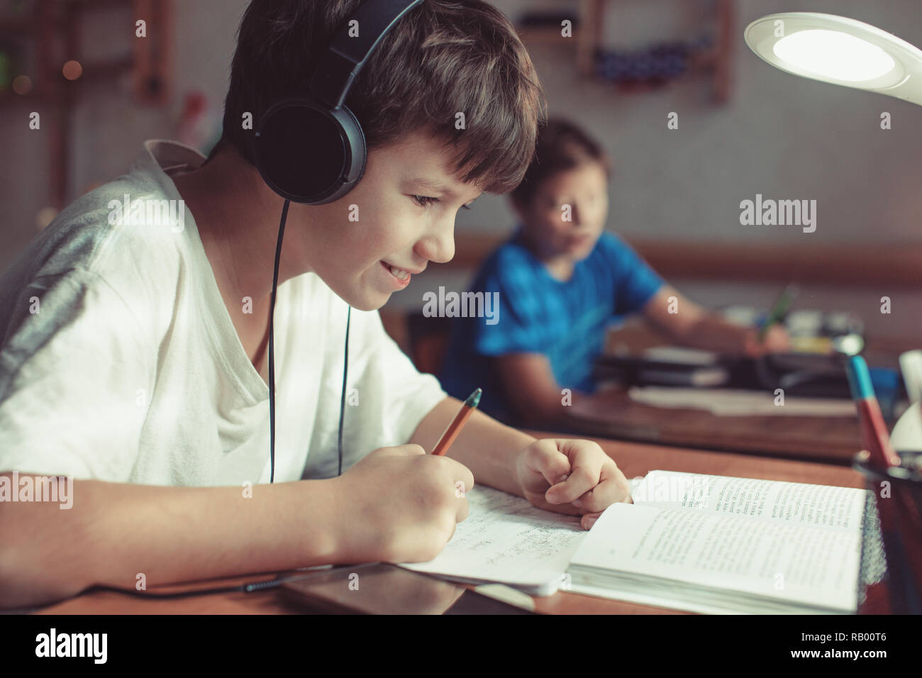 Piccolo felice caucasian scolari a fare i compiti a casa Foto Stock