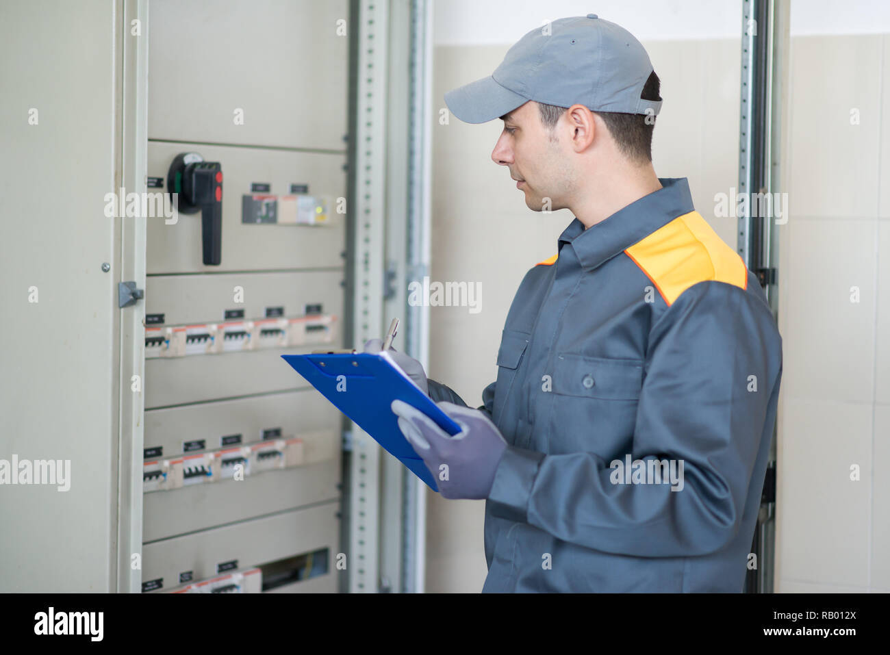 Ispettore elettricista controllo industriale scheda di distribuzione in una fabbrica Foto Stock