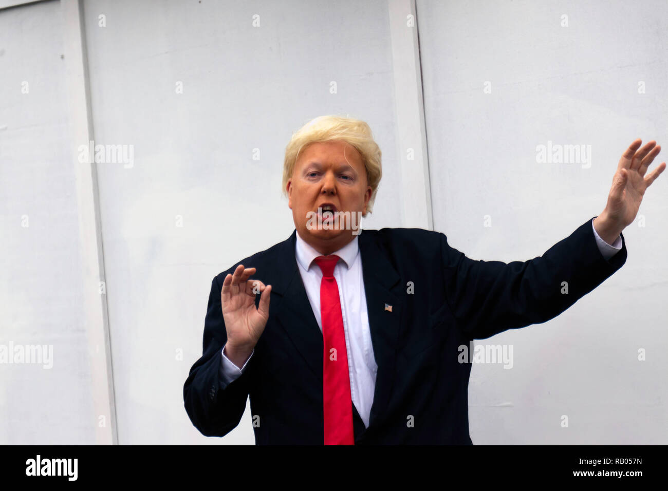 Un Donald Trump Impersonator, pone da un gigantesco muro che circonda il vecchio Tidemill Wildlife Garden, Deptford. Che è sotto la minaccia di distruzione da Lewisham Coulcil. Foto Stock