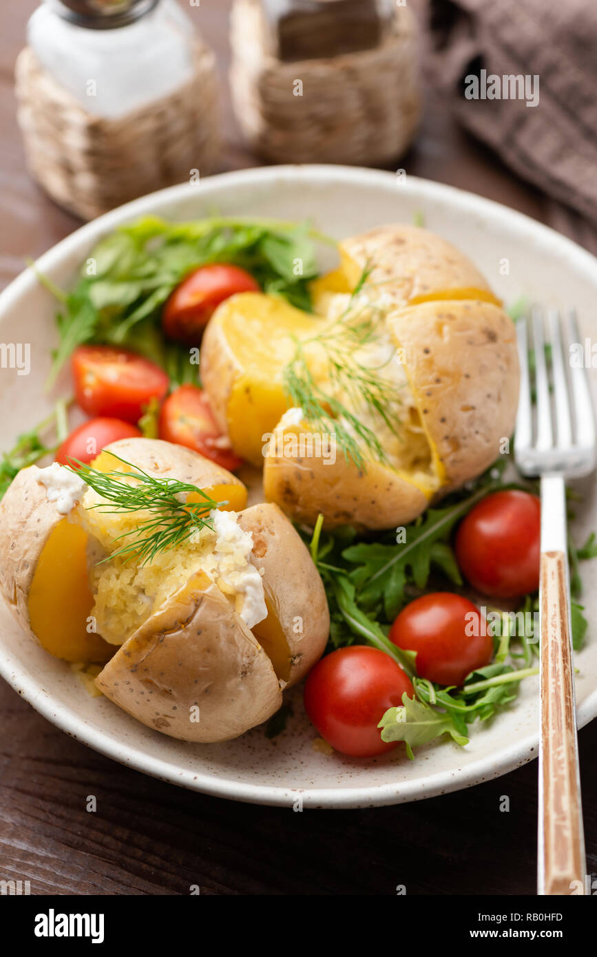 Patate Al Forno Ripiene Con Formaggio E Salsa Con Rucola Fresca Insalata Di Pomodoro Foto Stock Alamy