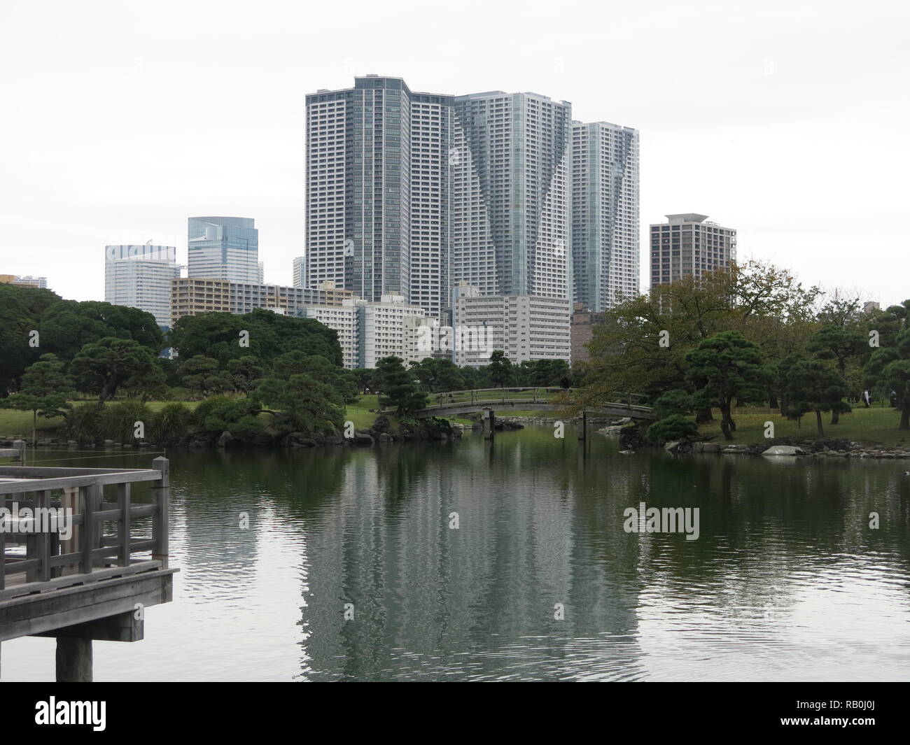 Sopraffatte da alte ufficio blocchi in Tokyo city centre, Hamarikyu Gardens è un verde parco pubblico con laghetto, passerelle, teahouse e da alberi di pino. Foto Stock