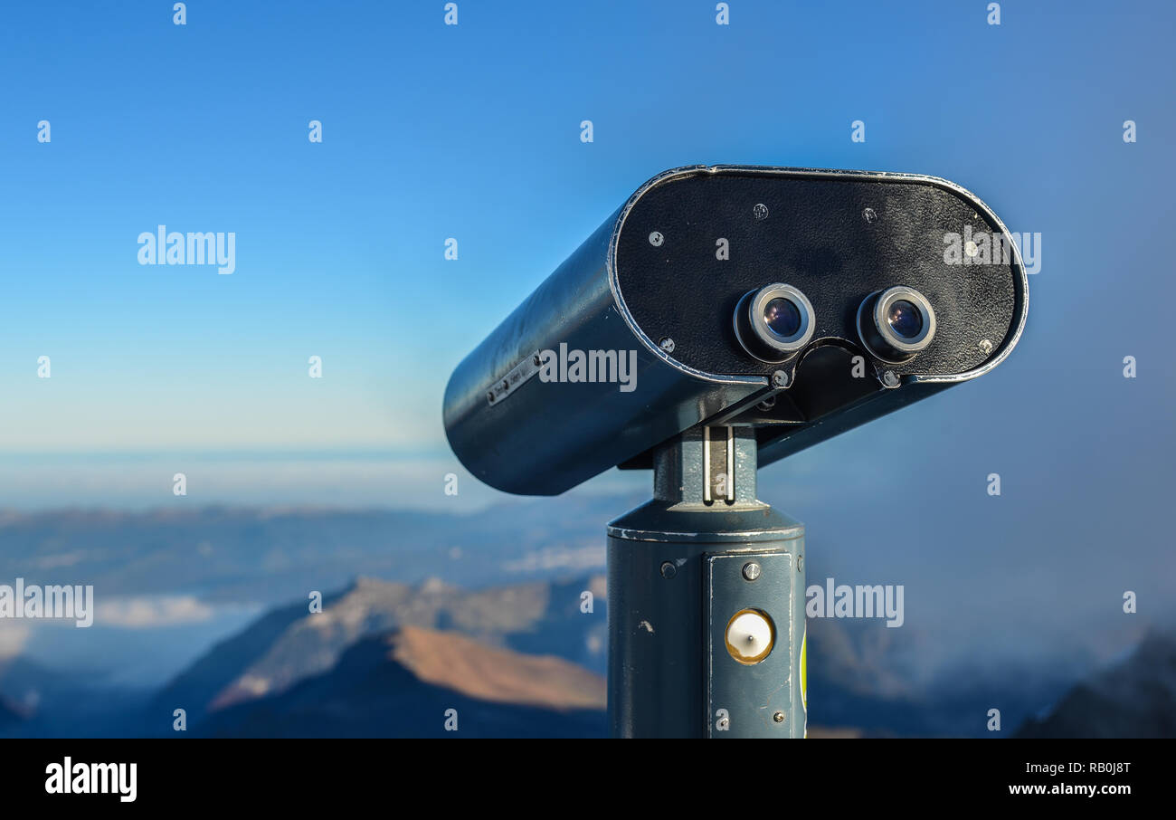 Binoculare pubblica di fronte ad una vista sulla montagna di neve di picchi in Jungfraujoch, Svizzera. Foto Stock