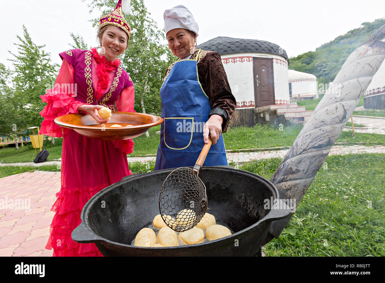 Il kazako donne rendendo tradizionale pane locale noto come Baursak, ad Almaty in Kazakistan. Foto Stock