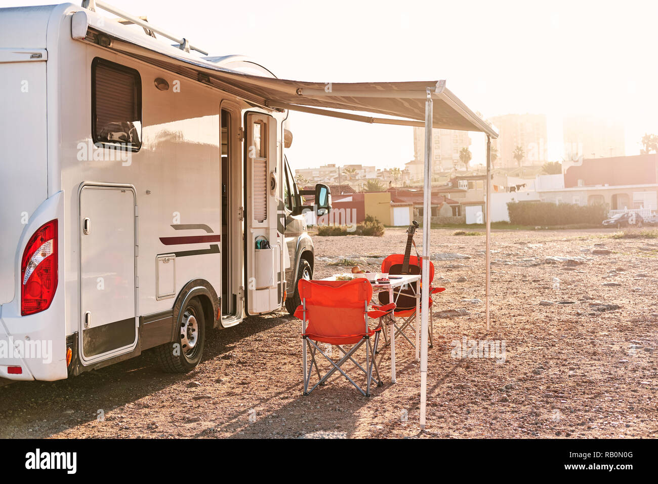 Vuoto sedie pieghevoli e la tabella sotto la tettoia vicino al veicolo per attività ricreative camper rimorchio. Avventura, persone attive che viaggiano dal motore home concetto Foto Stock
