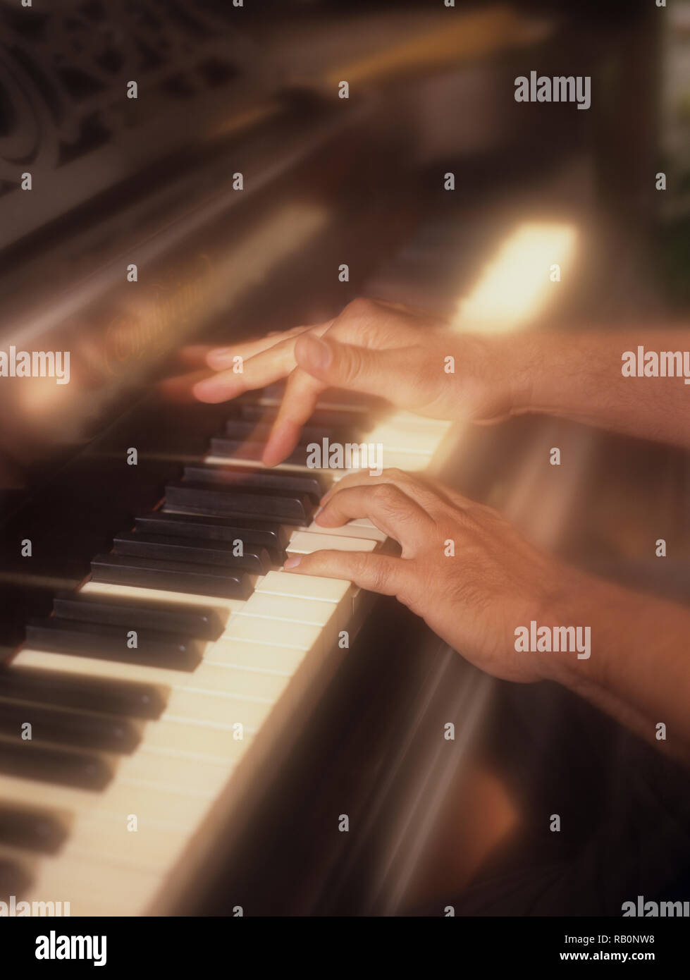 Uomo giocando attivamente il pianoforte con un morbido effetto di filtro per enfatizzare la pressione dei tasti di pianoforte in tempo reale Foto Stock