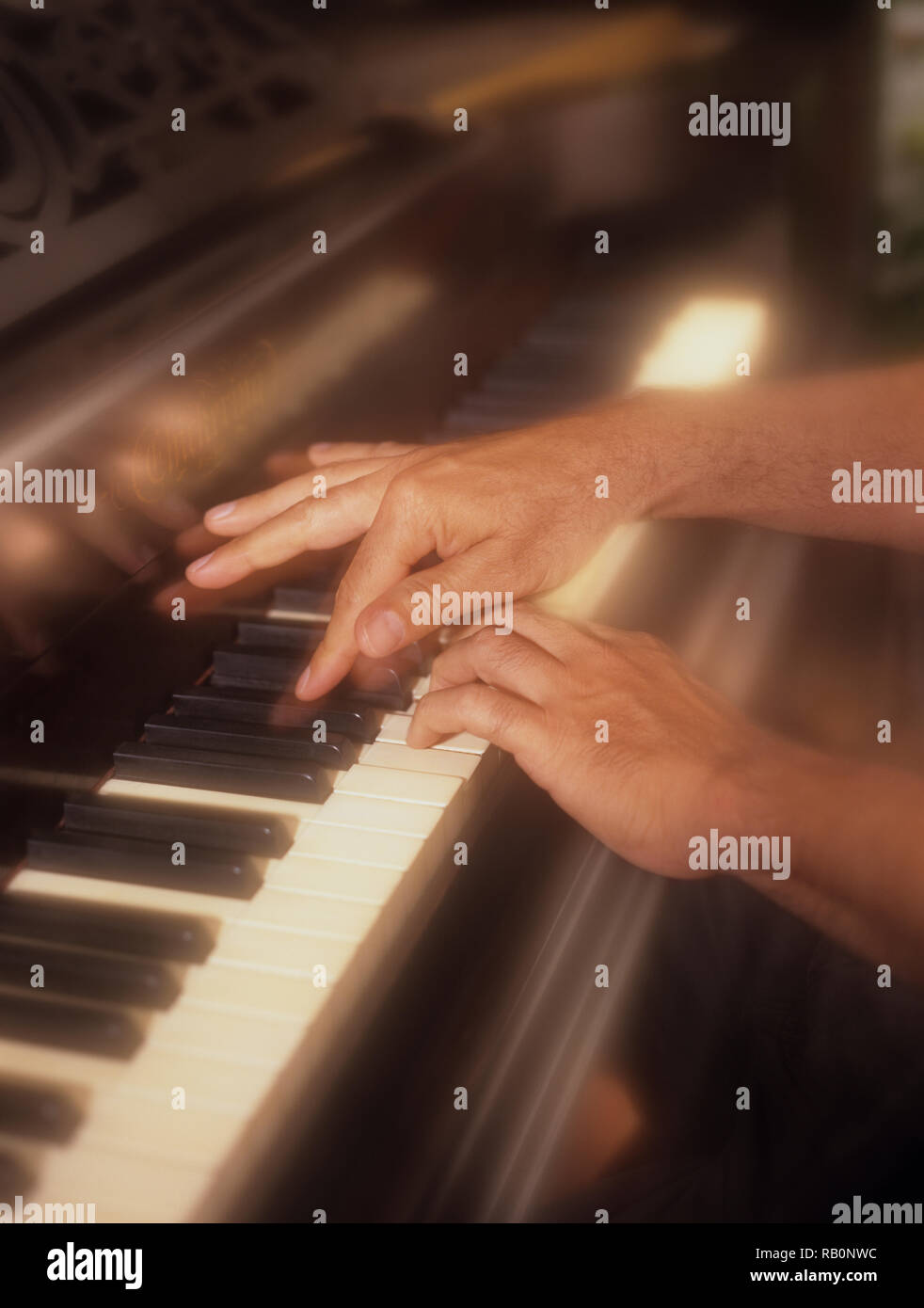 Uomo giocando attivamente il pianoforte con un morbido effetto di filtro per enfatizzare la pressione dei tasti di pianoforte in tempo reale Foto Stock