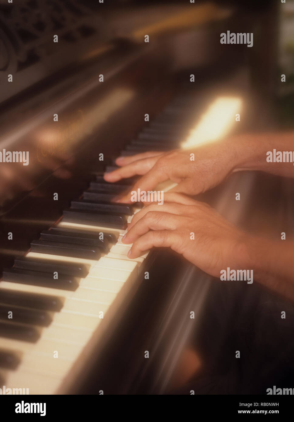 Uomo giocando attivamente il pianoforte con un morbido effetto di filtro per enfatizzare la pressione dei tasti di pianoforte in tempo reale Foto Stock