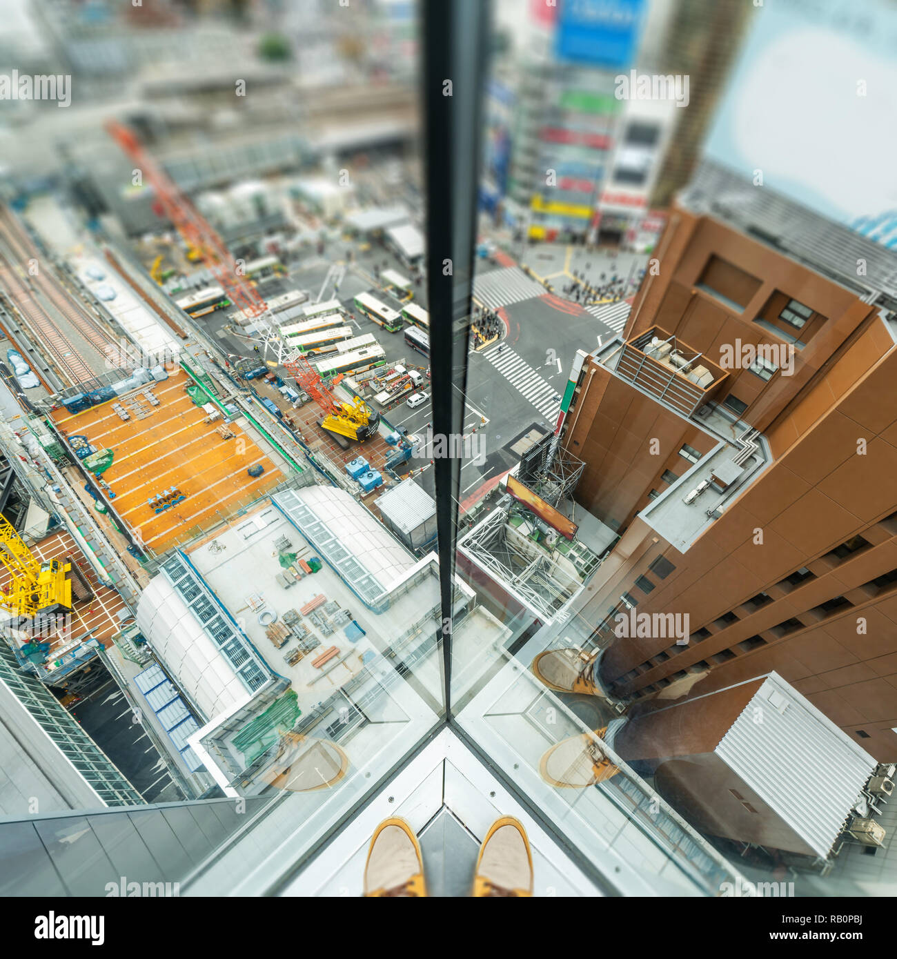 Asia Business concept per il settore immobiliare e costruzione aziendale - uomo stare accanto alla finestra con lo skyline della città vista aerea in Shibuya, Tokyo, Giappone Foto Stock