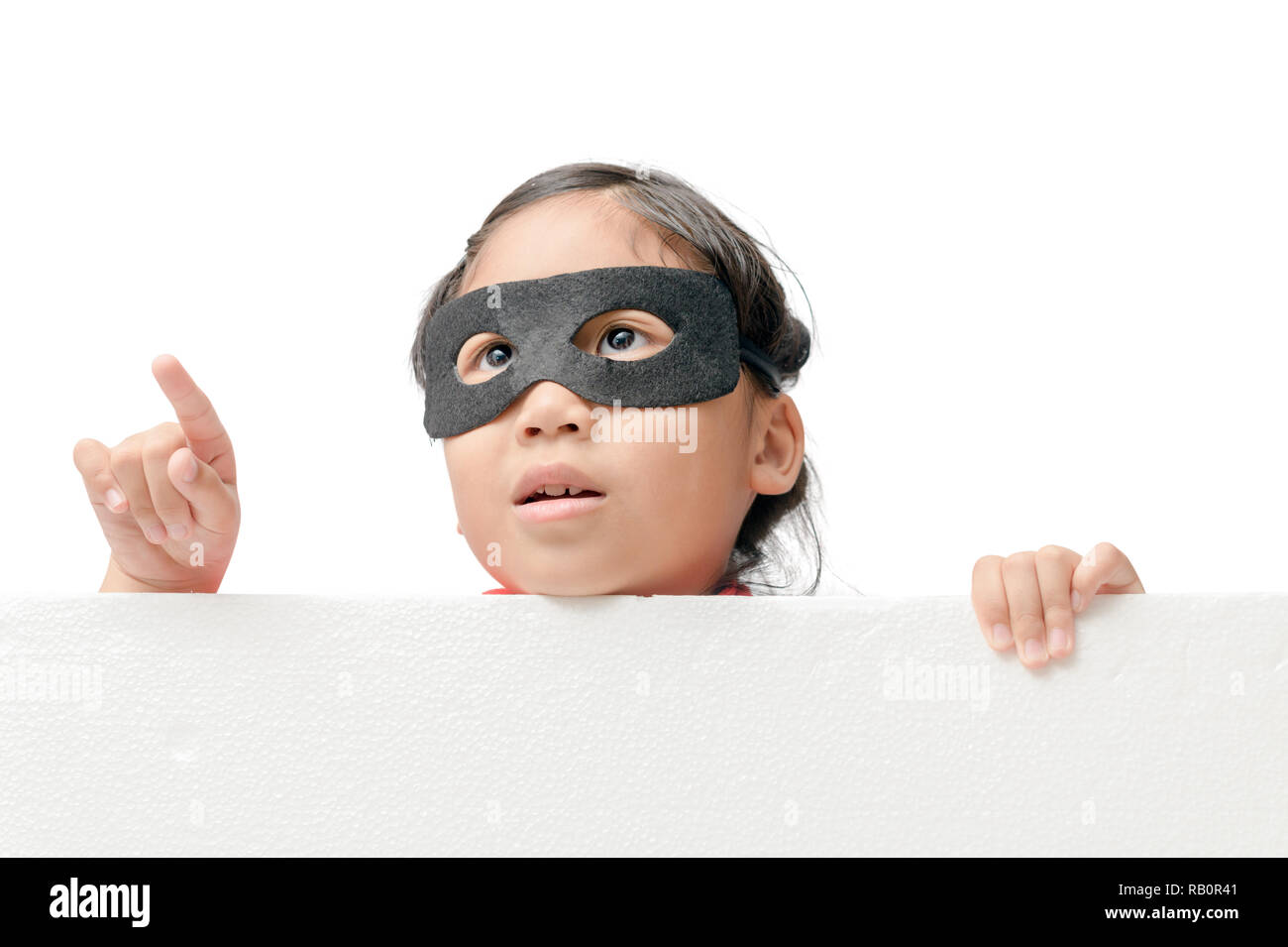 Il supereroe ragazza isolato di puntamento su sfondo bianco con copia spazio per il testo di input Foto Stock