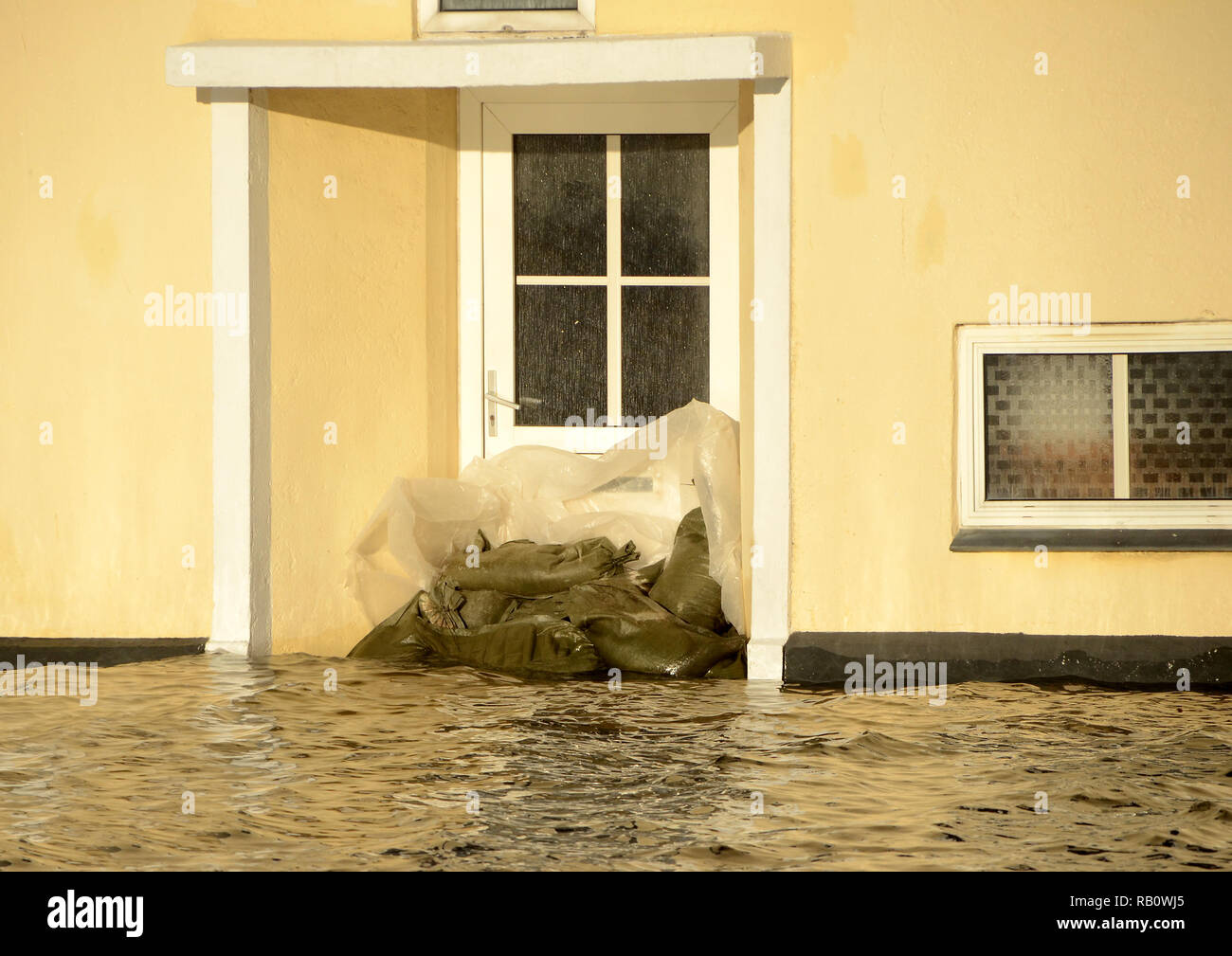 Una porta bloccata con sacchi di sabbia, a causa di una mareggiata. Foto Stock