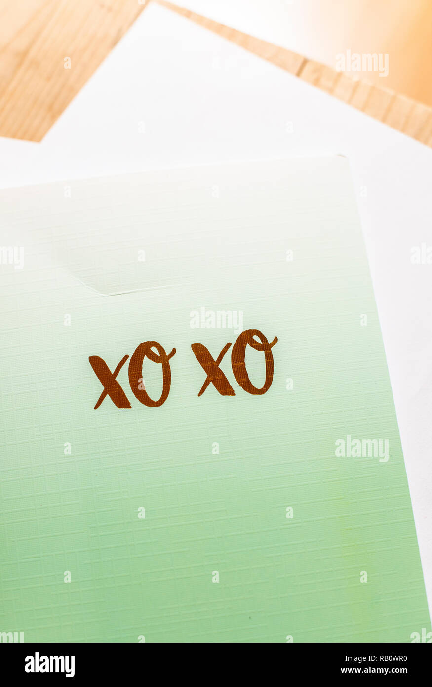 Xo Xo testo sul notebook verde su un tavolo. Concetto di baci e abbracci in una lettera con caratteri XO. Foto Stock