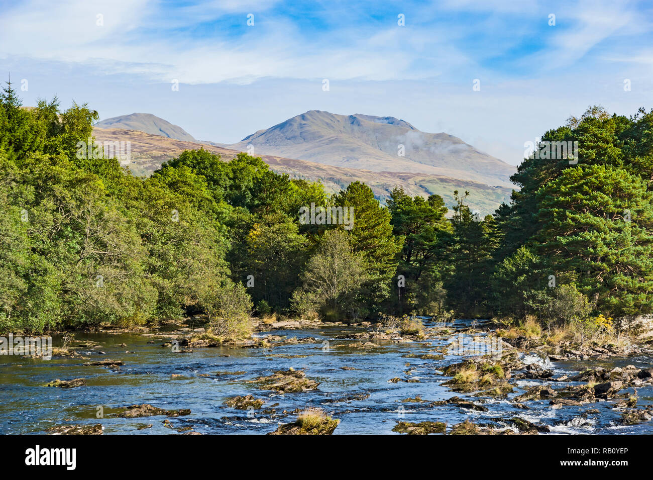 Le Cascate di Dochart a Killin in Scozia su una soleggiata giornata autunnale con Ben Lawers (R) e Beinn Ghlas (L) che forniscono lo sfondo Foto Stock