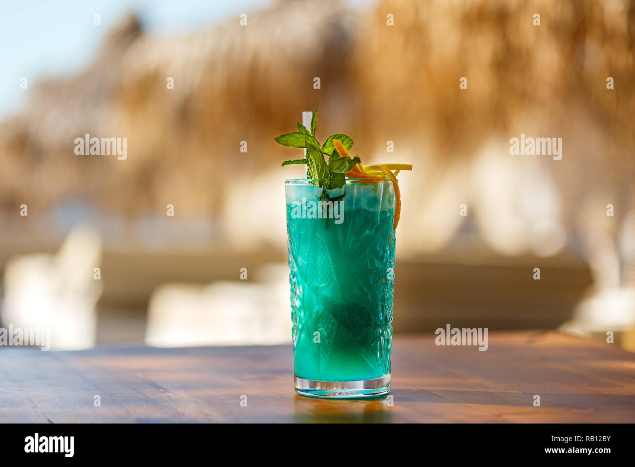 Vetro cristallo di verde drink sulla spiaggia tabella Foto Stock