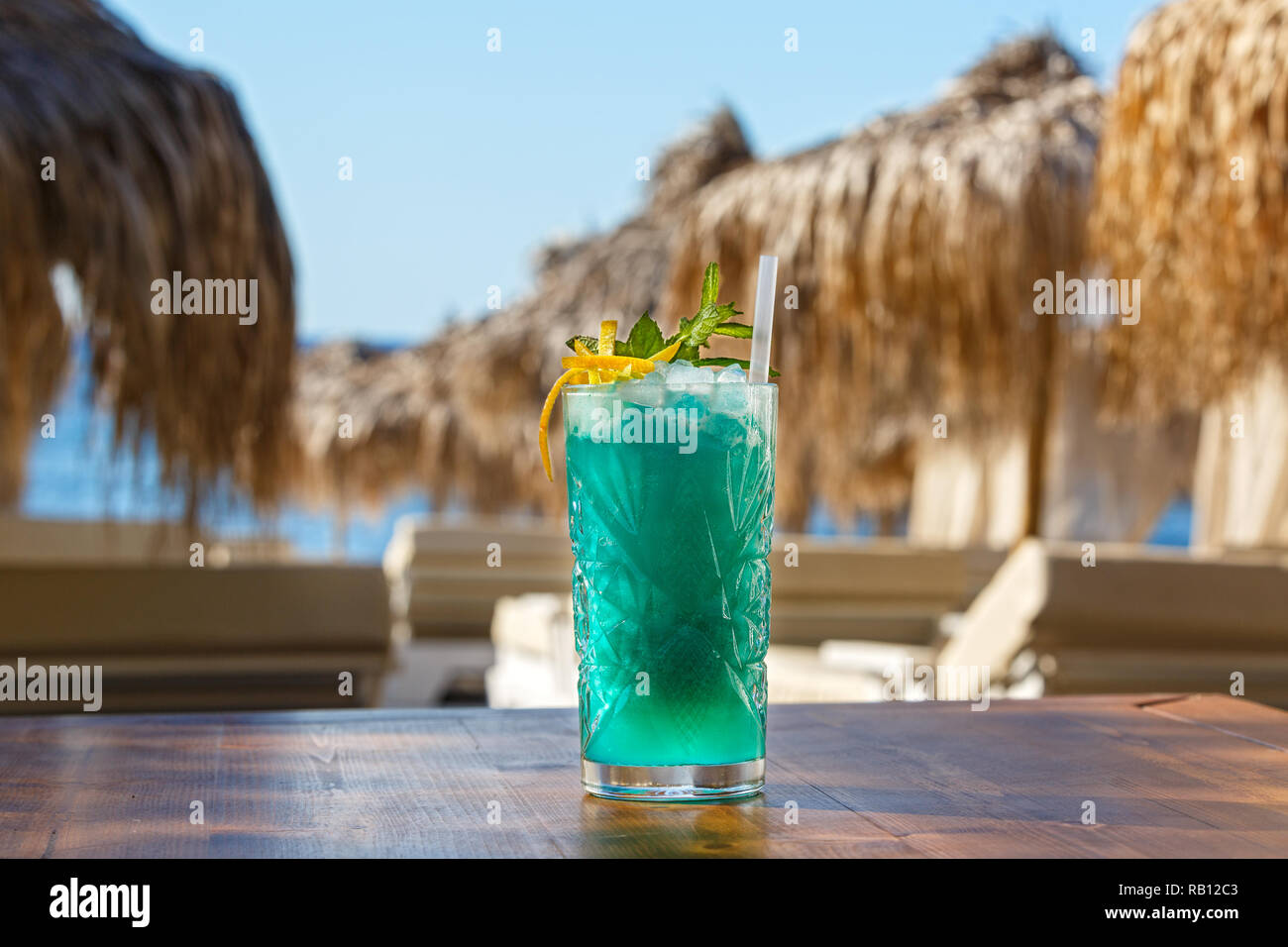 Vetro cristallo di verde drink sulla spiaggia tabella Foto Stock