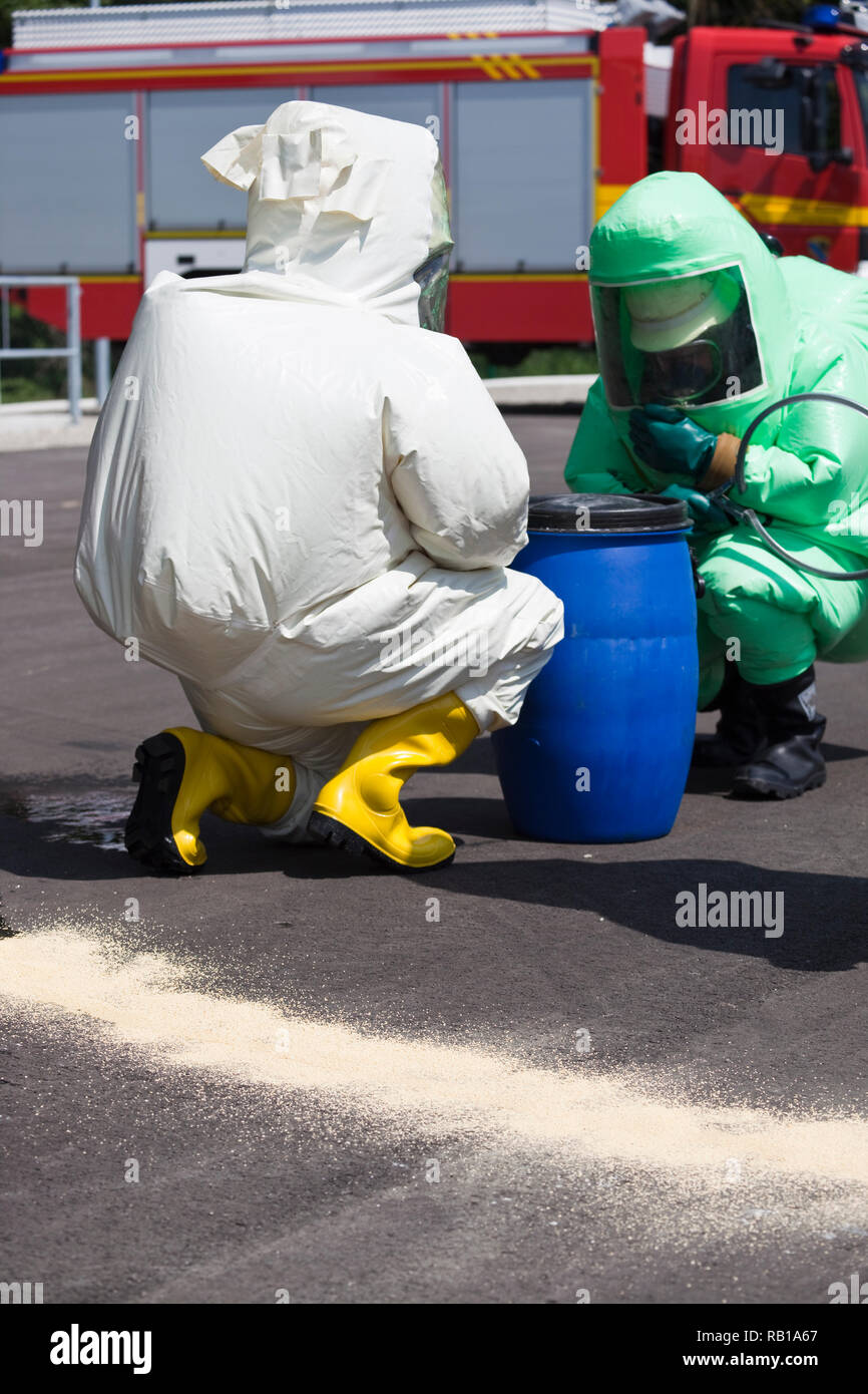 Due uomini in abbigliamento protettivo pulizia dopo il disastro chimico. L'ingranaggio gonfiabile protegge anche contro la contaminazione con particelle radioattive, AG Foto Stock