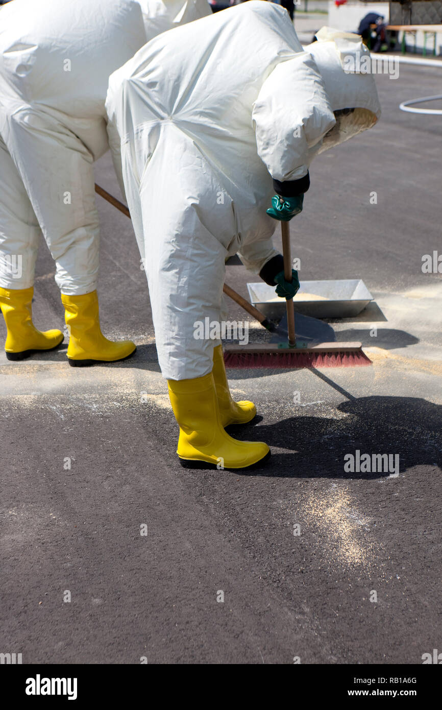 Due uomini in abbigliamento protettivo pulizia dopo l incidente chimico. L'ingranaggio gonfiabile protegge anche contro la contaminazione con particelle radioattive, AG Foto Stock