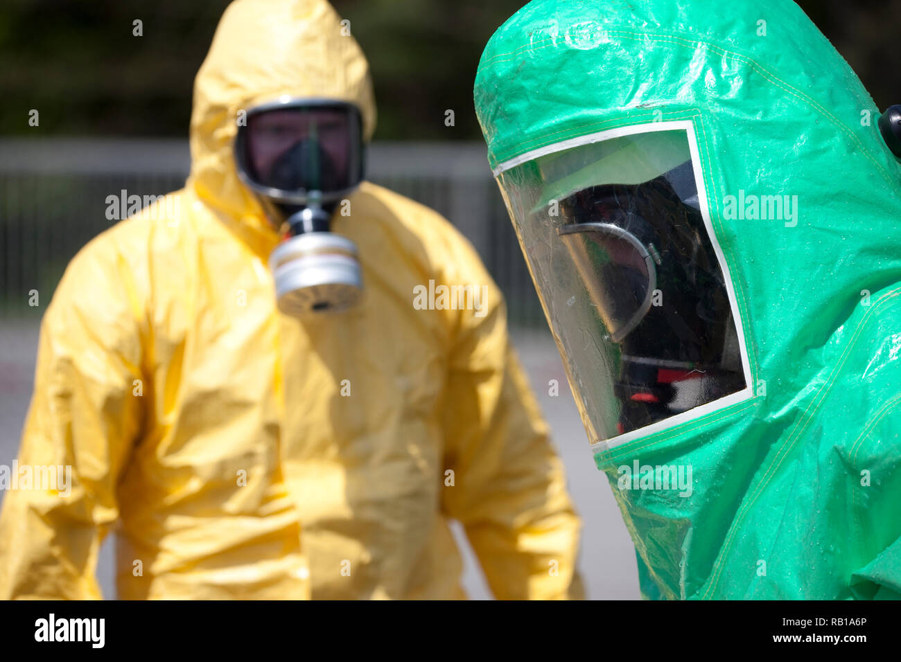Due uomini in abbigliamento protettivo pulizia dopo l incidente chimico o la radiazione incidente. L'ingranaggio gonfiabile a destra protegge contro la contaminazione Foto Stock