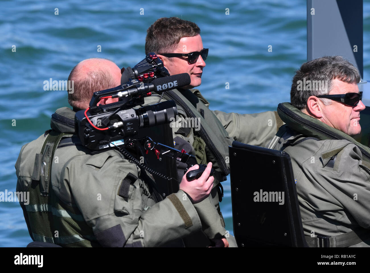 Film militare equipaggio su una barca facendo un video promozionale nel Regno Unito. Foto Stock