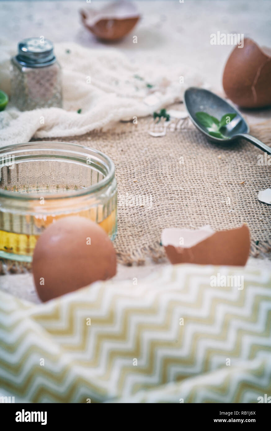 Uovo crudo di gallina e vuoti cracked conchiglie sulla parte superiore di tavolo da cucina Foto Stock