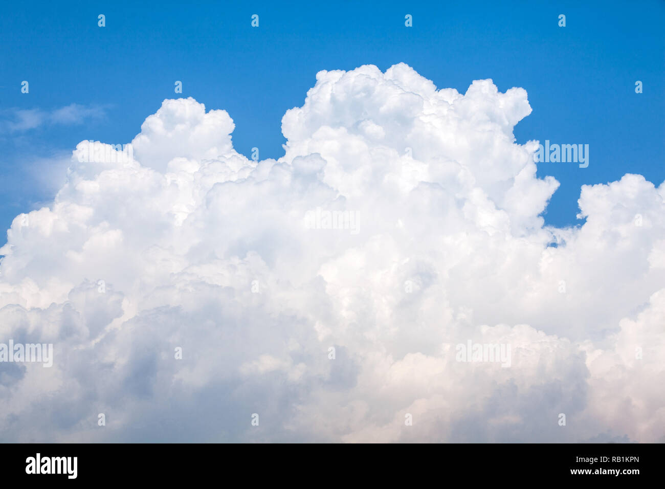 Grande bianco puffy cloud sul cielo blu Foto Stock