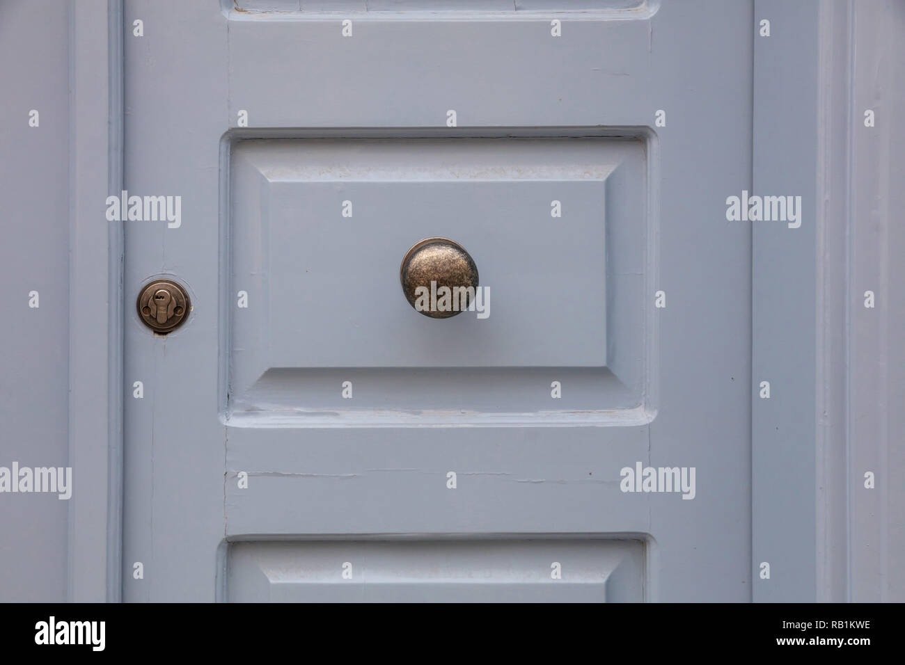 Ottone antico la manopola della porta su un livello di grigio di legno verniciato porta di ingresso, edificio residenziale nella città vecchia di Plaka, Atene Grecia Foto Stock