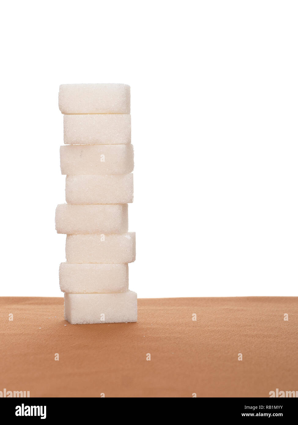Pila di otto cubetti di zucchero sul tessuto, sfondo bianco. Mangiare sano. Foto Stock