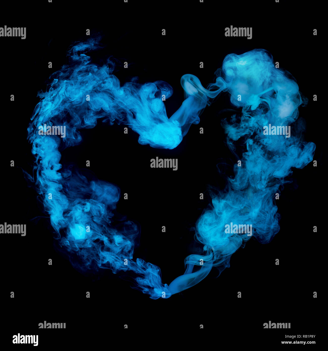 Forma di cuore da fumo blu isolato su sfondo nero Foto Stock