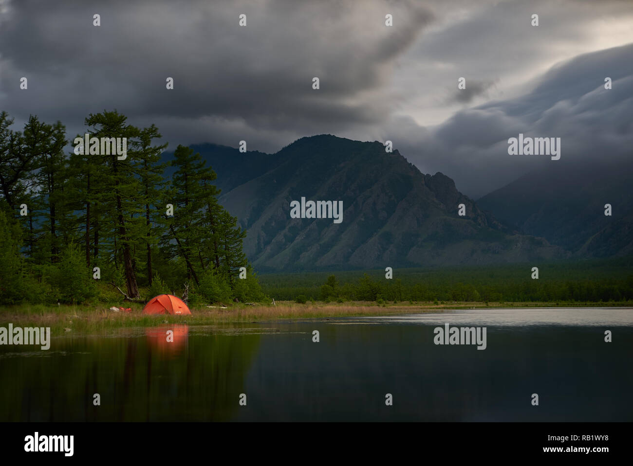 Tenda arancione sulla costa del lago di notte. Foto Stock