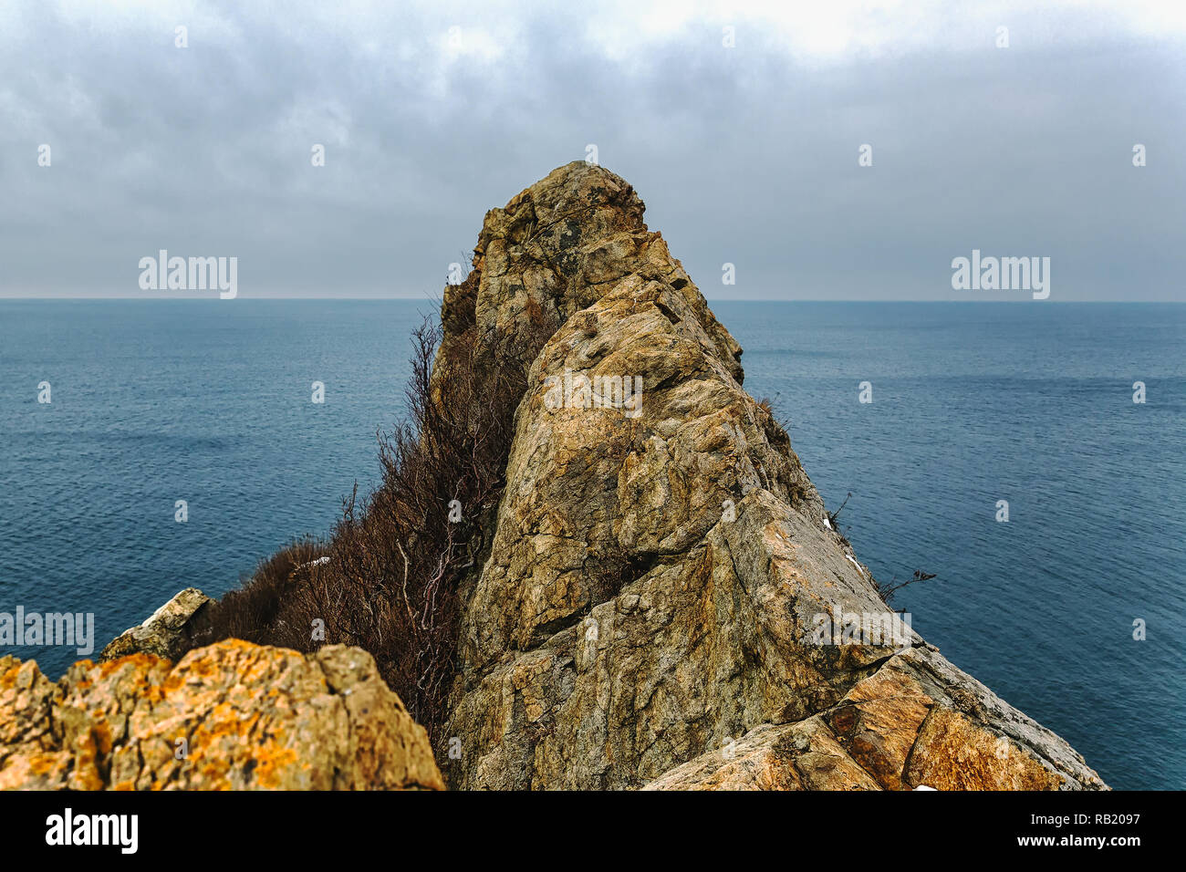 Alta scogliera rocciosa di picco e con vista sul mare Foto Stock