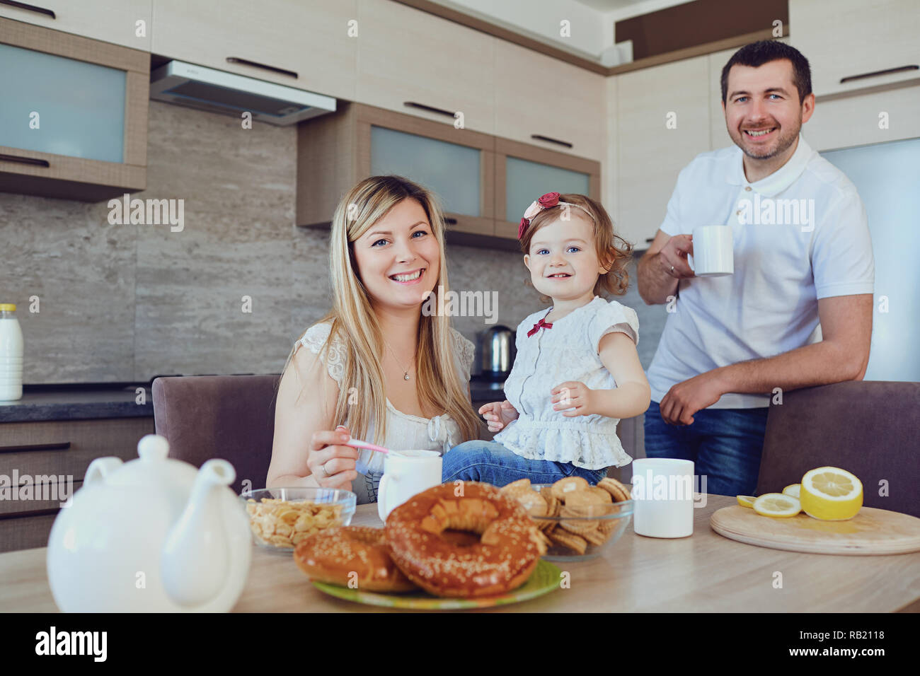Una famiglia felice in cucina seduti ad un tavolo. Foto Stock
