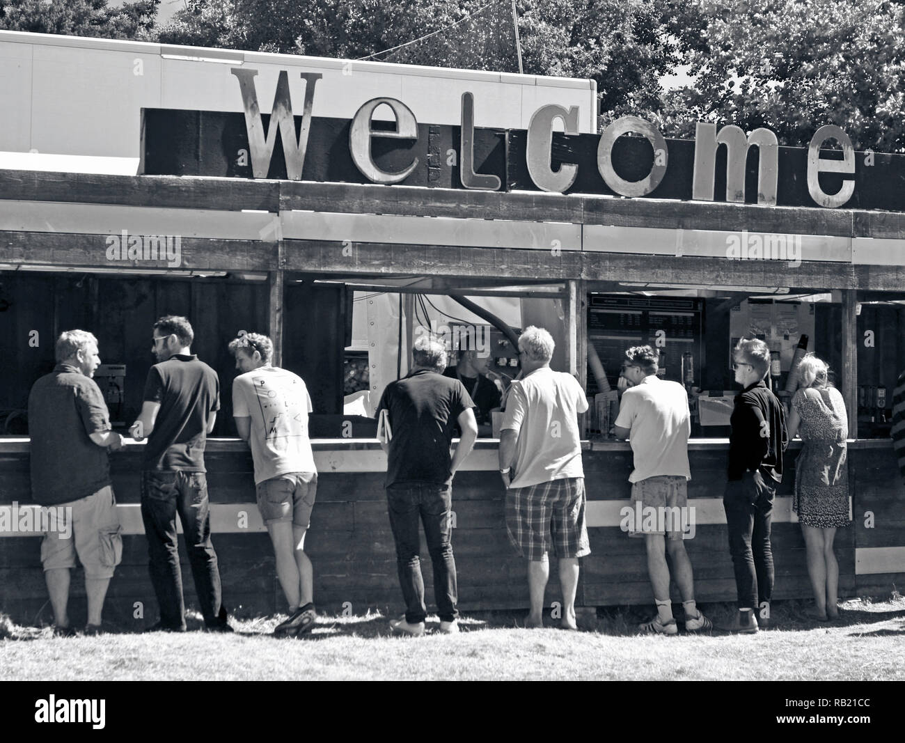 Sette uomini e una donna in piedi al bar a latitude music festival henham Inghilterra SUFFOLK REGNO UNITO Foto Stock