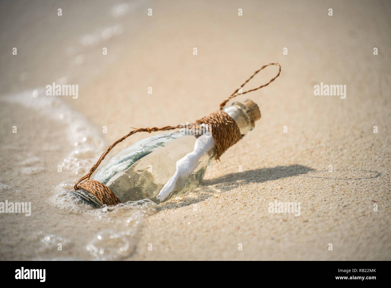 Lettera messaggio in un bicchiere bottiglia trasparente sulla spiaggia , concept per la comunicazione. Foto Stock
