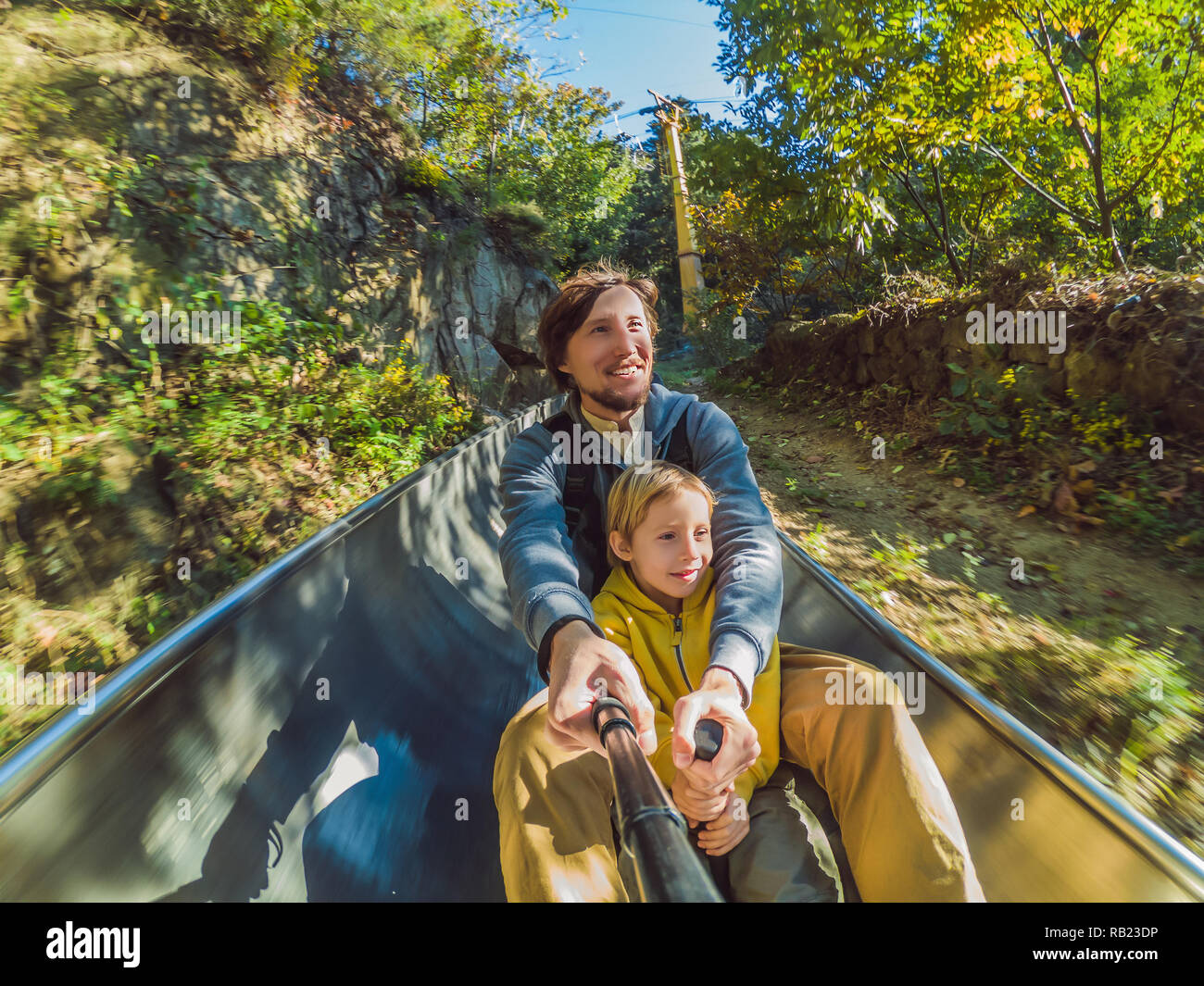 Papà e figlio divertirsi sul rullo alpine coaster Foto Stock