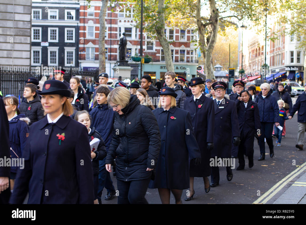 Veterani e soldati festeggiare e rendere omaggio e rispettare durante il giorno del ricordo per le strade di Londra che indossa il papavero. Foto Stock