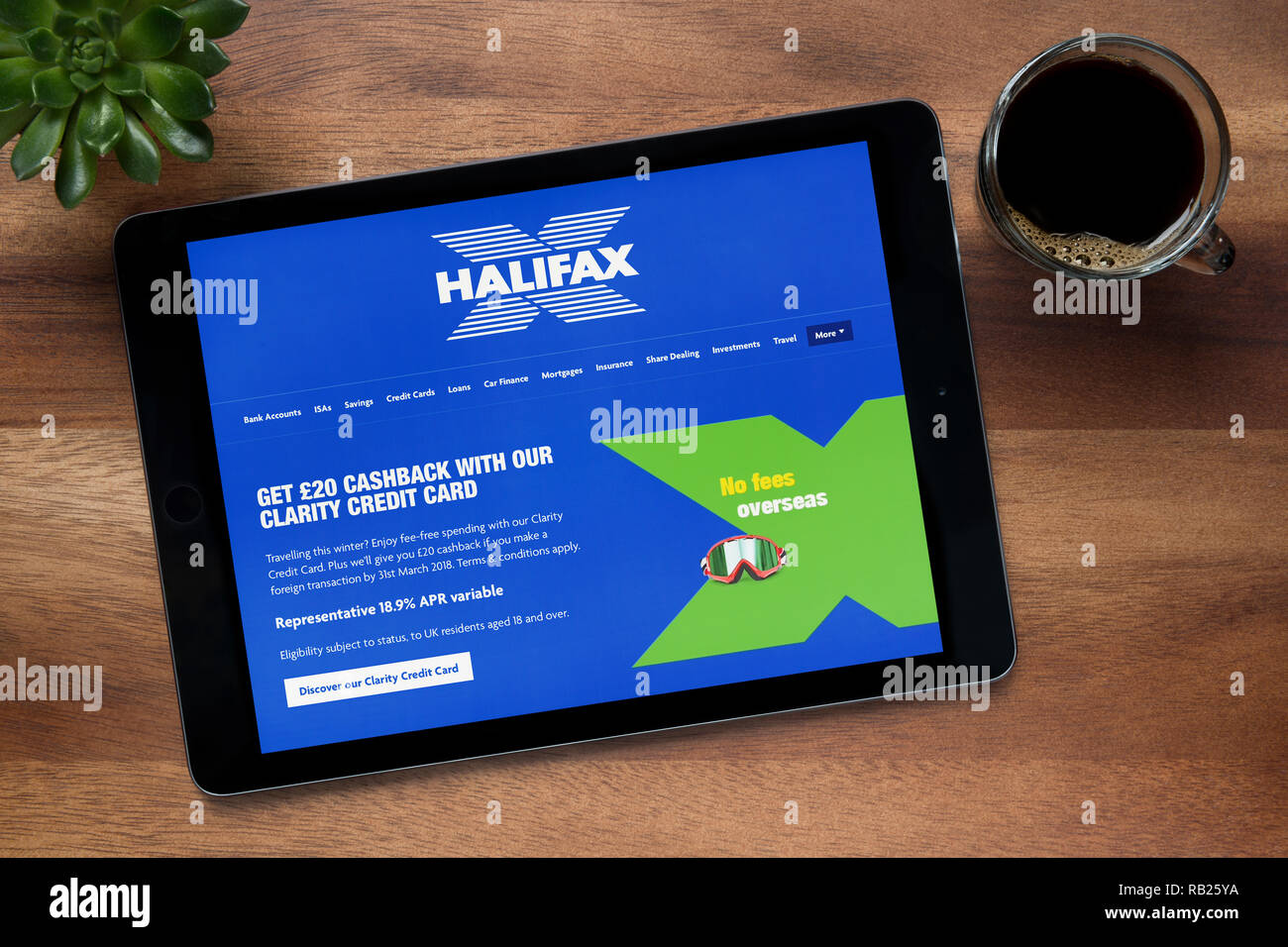 Il sito web di Halifax è visto su un tablet iPad, su di un tavolo di legno lungo con un caffè espresso e una pianta di casa (solo uso editoriale). Foto Stock