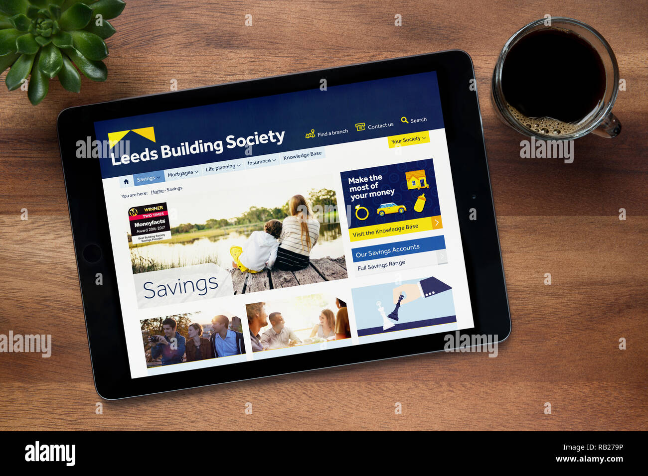 Il sito web di Leeds Building Society è visto su un tablet iPad, su di un tavolo di legno lungo con un caffè espresso e una pianta di casa (solo editoriale). Foto Stock