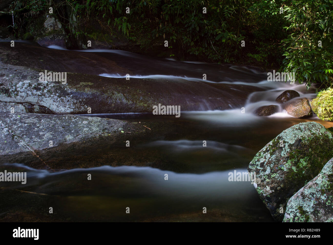 Creek al di sotto di una cascata Poço 13, Macumba, tra Petropolis e Teresopolis, stato di Rio de Janeiro, Brasile, con esposizione lunga Foto Stock