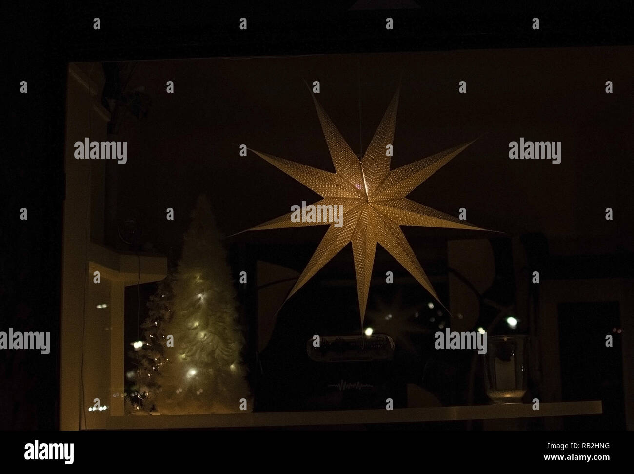 Avvento star decorazioni di Natale nella finestra nelle tenebre. Foto Stock