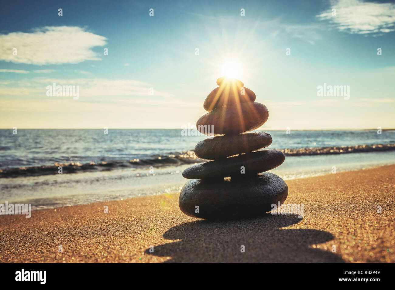 Equilibrio di pietre sulla spiaggia, sunrise shot. Meditazione Zen. Foto Stock