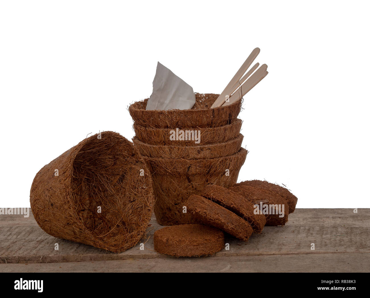 Filati di cocco vasi per piante e compressa compost con semi e le etichette di legno. Ecologico giardinaggio a molla. Isolato su sfondo bianco. Foto Stock