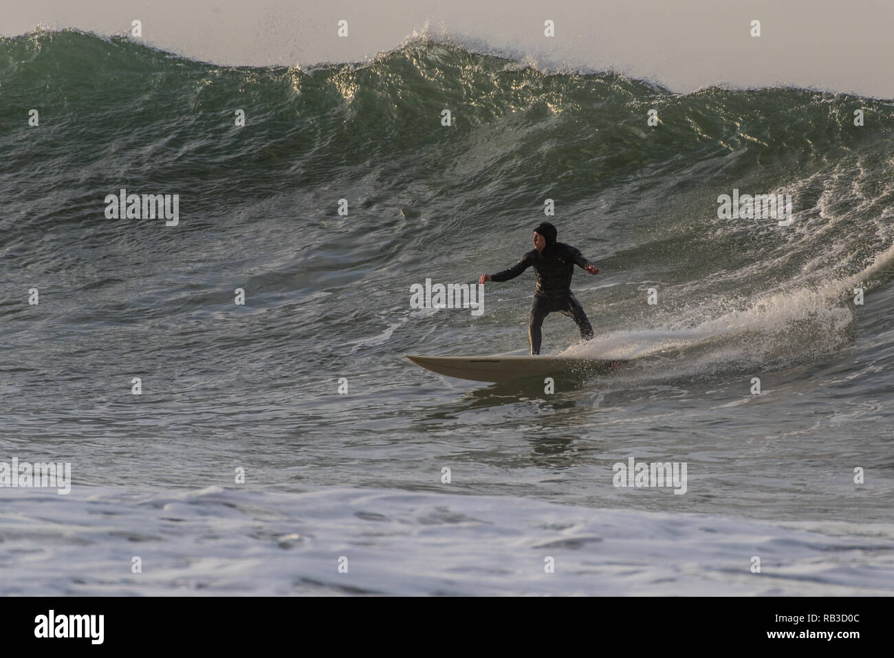 Brave goofyfoot surfer in caduta sulla grande onda impostata durante il divertimento in inverno si gonfiano in Ventura, California, Stati Uniti d'America il 6 gennaio 2019. Foto Stock